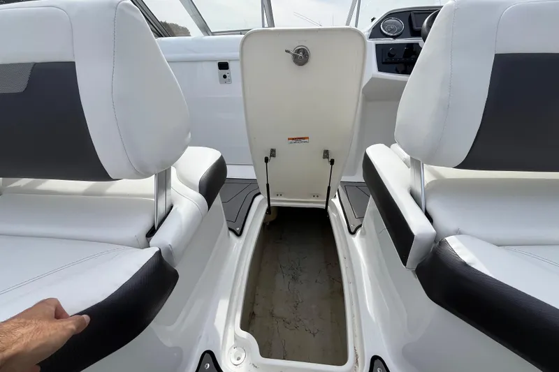 Slide: The Image of 2023 Hurricane SunDeck 235 OB interior with white seating and storage compartment. - 31