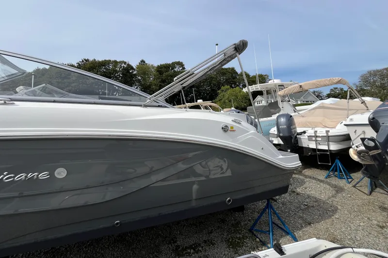 Slide: The Image of 2023 Hurricane SunDeck 235 OB boat on display, surrounded by other boats. - 6