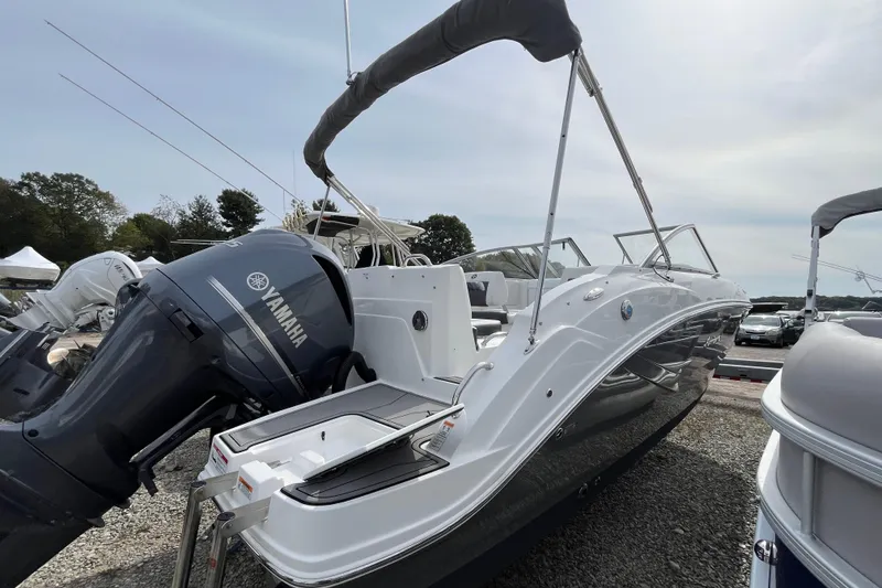 Slide: The Image of 2023 Hurricane SunDeck 235 OB boat with Yamaha outboard motor, docked outdoors. - 8