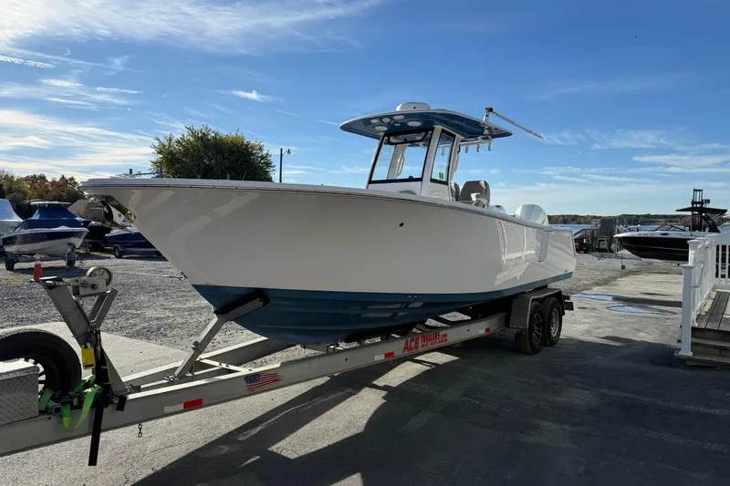 Slide: The Image of 2022 Sportsman Open 262 Center Console boat on trailer, parked outdoors under clear sky. - 5