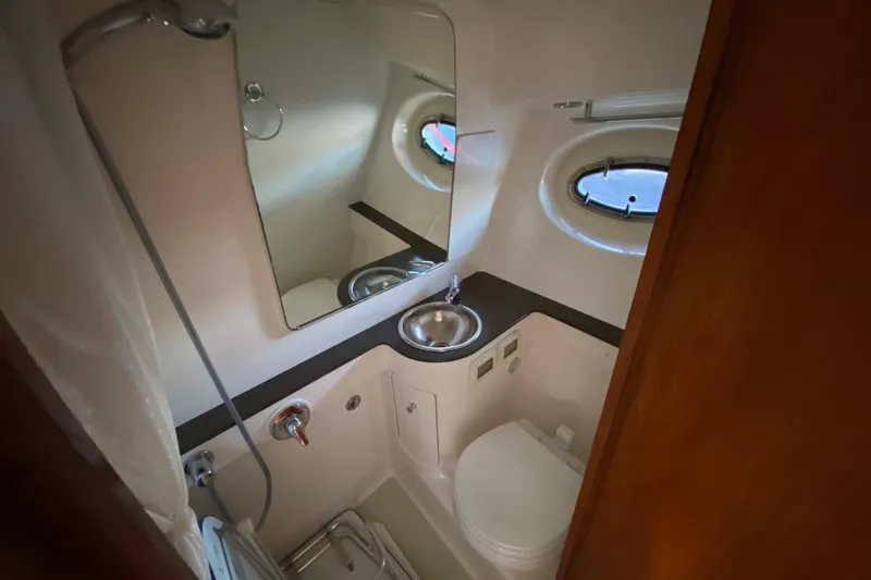 Slide: The Image of Compact bathroom in 2004 Tiara Yachts 3200 Open, featuring sink, toilet, and mirror. - 11