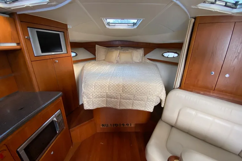 Slide: The Image of 2004 Tiara Yachts 3200 Open cabin interior with bed, TV, and kitchenette. - 13