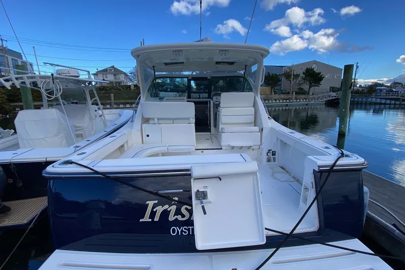 Slide: The Image of 2004 Tiara Yachts 3200 Open docked, featuring spacious seating and sleek design. - 2