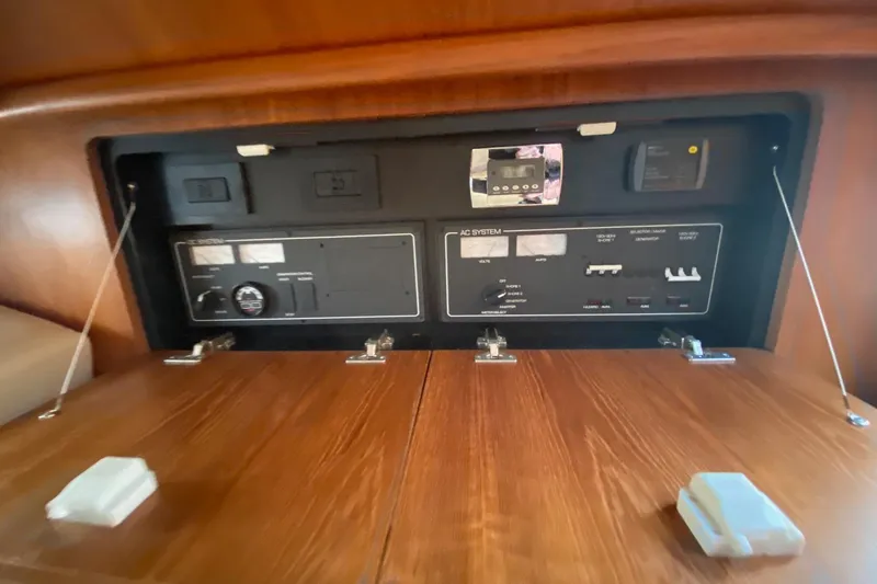 Slide: The Image of 2004 Tiara Yachts 3200 Open electrical panel with wooden cabinet doors. - 25