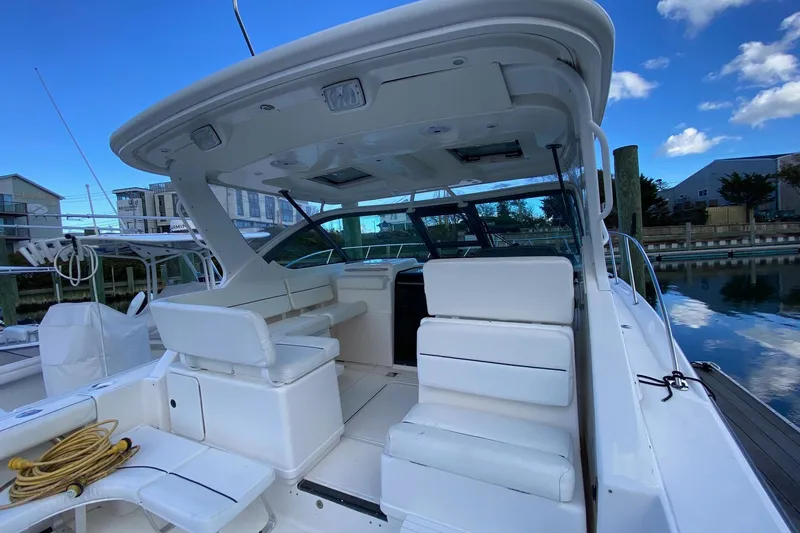 Slide: The Image of 2004 Tiara Yachts 3200 Open boat interior with white seating and canopy. - 3