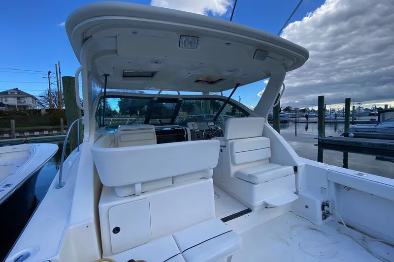 Slide: The Image of 2004 Tiara Yachts 3200 Open boat interior at marina, featuring seating and helm. - 4