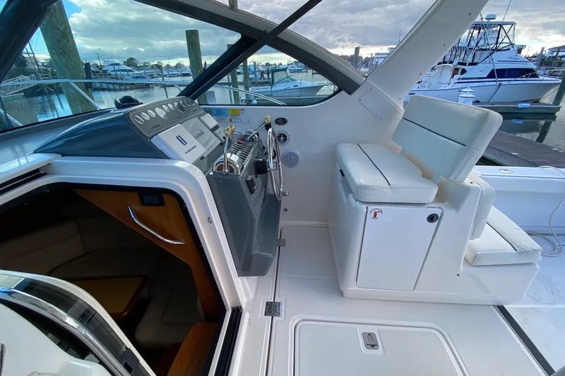 Slide: The Image of 2004 Tiara Yachts 3200 Open cockpit with helm, seating, and marina view. - 6