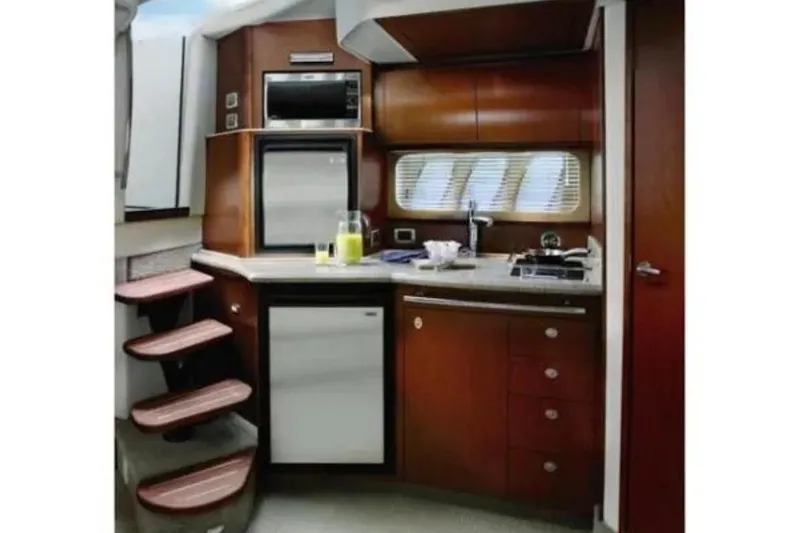 Slide: The Image of Interior of 2008 Sea Ray 38 Sundancer yacht kitchen with modern appliances and wooden cabinetry. - 18