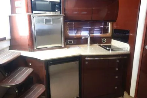 Slide: The Image of 2008 Sea Ray 380 Sundancer yacht kitchen with modern appliances and wooden cabinetry. - 19