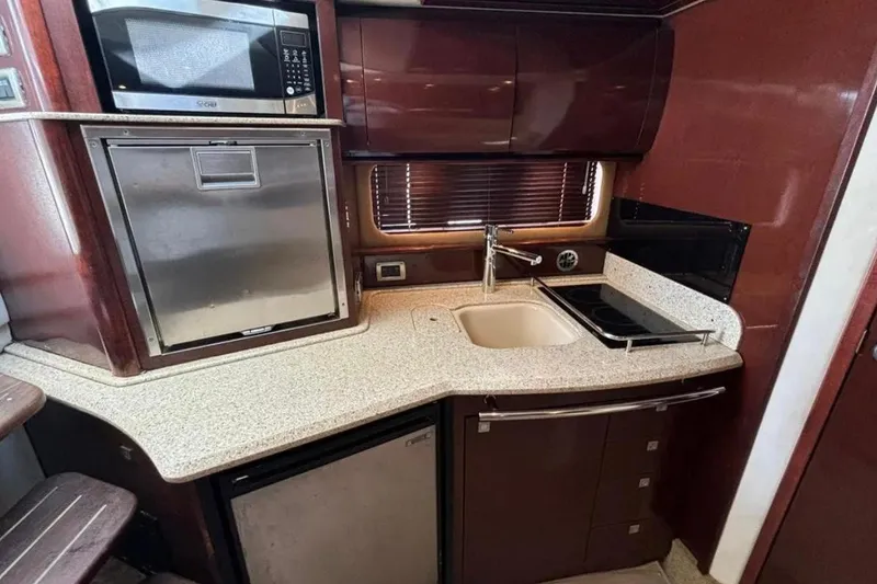 Slide: The Image of 2008 Sea Ray 38 Sundancer yacht kitchen with microwave, sink, and stove. - 20