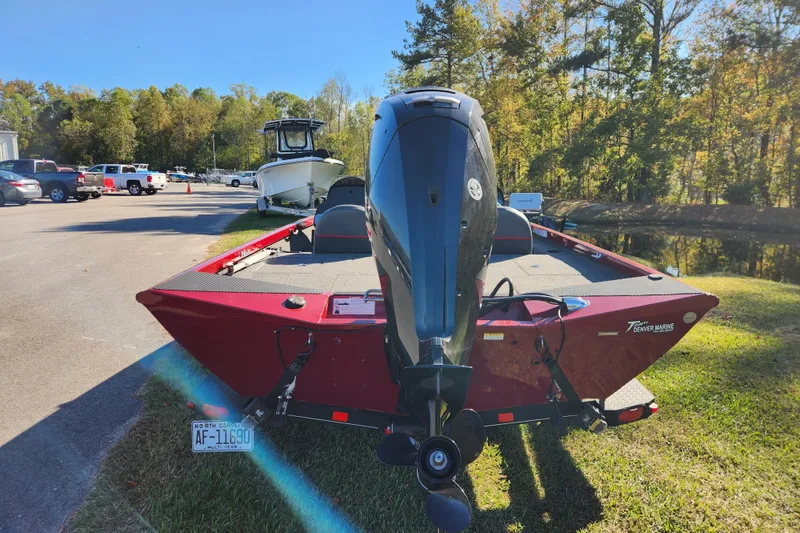 Slide: The Image of 2016 Ranger RT188 boat with outboard motor, parked on grass near a road and trees. - 3