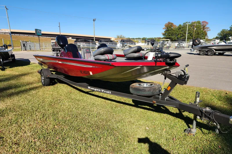 Slide: The Image of 2016 Ranger RT188 boat on trailer, parked on grass under clear blue sky. - 6