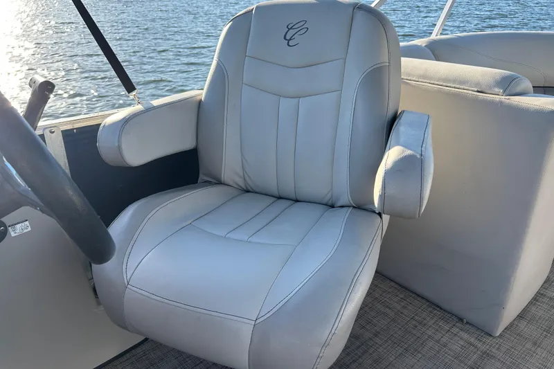 Slide: The Image of Captain's chair on 2022 Cypress Cay Seabreeze 232 boat, with embroidered logo, by the water. - 13