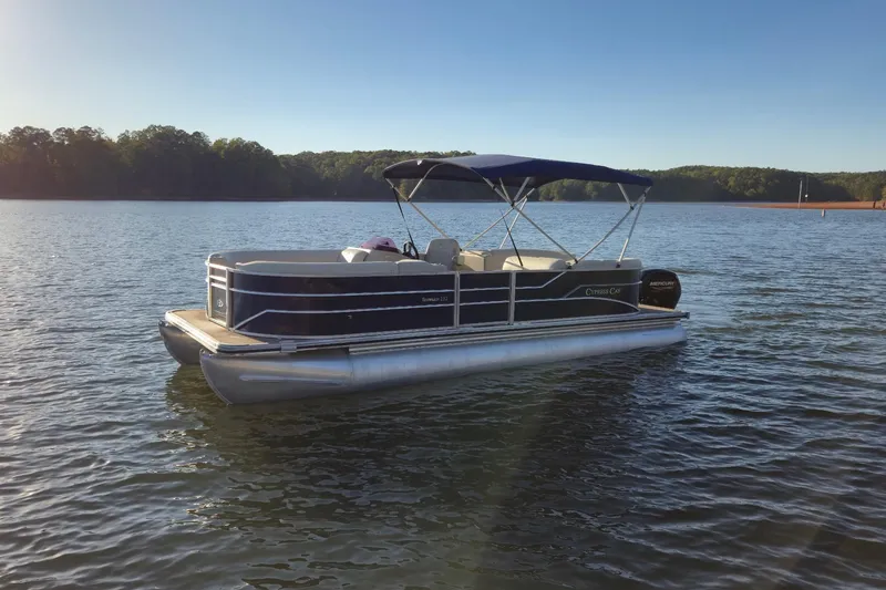 Slide: The Image of 2022 Cypress Cay Seabreeze 232 pontoon boat on a serene lake. - 2