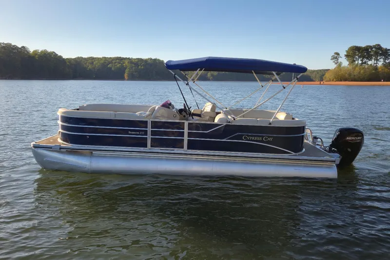 Slide: The Image of 2022 Cypress Cay Seabreeze 232 pontoon boat on a serene lake. - 3