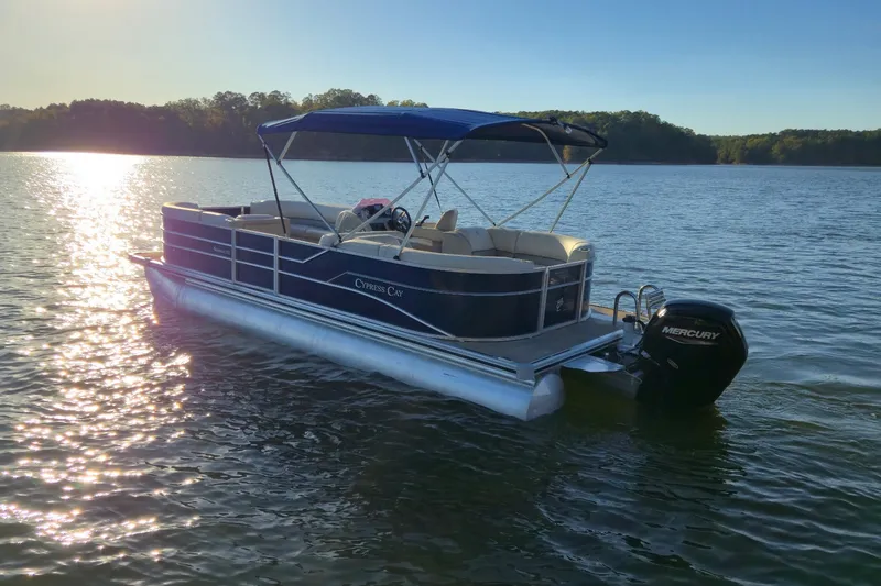 Slide: The Image of 2022 Cypress Cay Seabreeze 232 pontoon boat on a serene lake at sunset. - 4