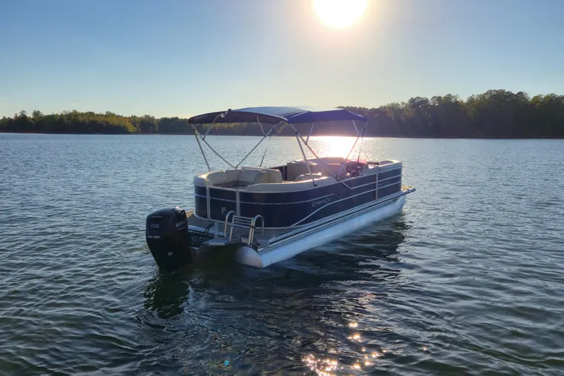 Slide: The Image of 2022 Cypress Cay Seabreeze 232 pontoon boat on a serene lake at sunset. - 5
