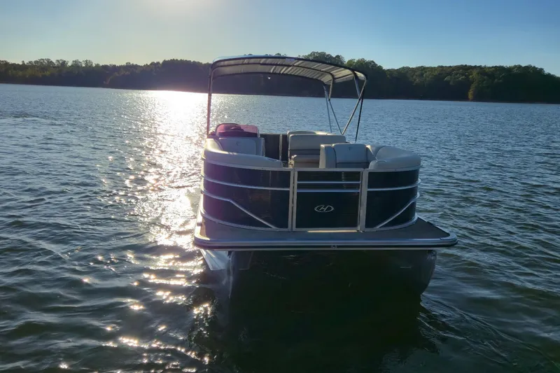 Slide: The Image of 2022 Cypress Cay Seabreeze 232 pontoon boat on a serene lake at sunset. - 6