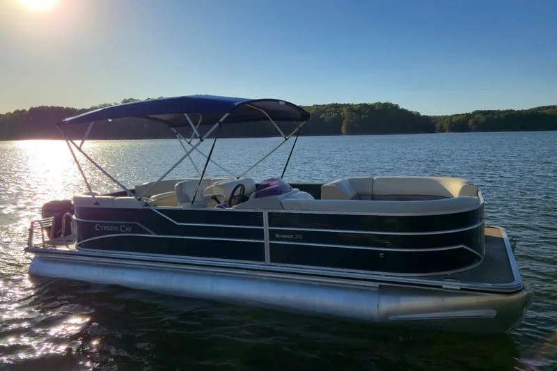 Slide: The Image of 2022 Cypress Cay Seabreeze 232 pontoon boat on a serene lake at sunset. - 7