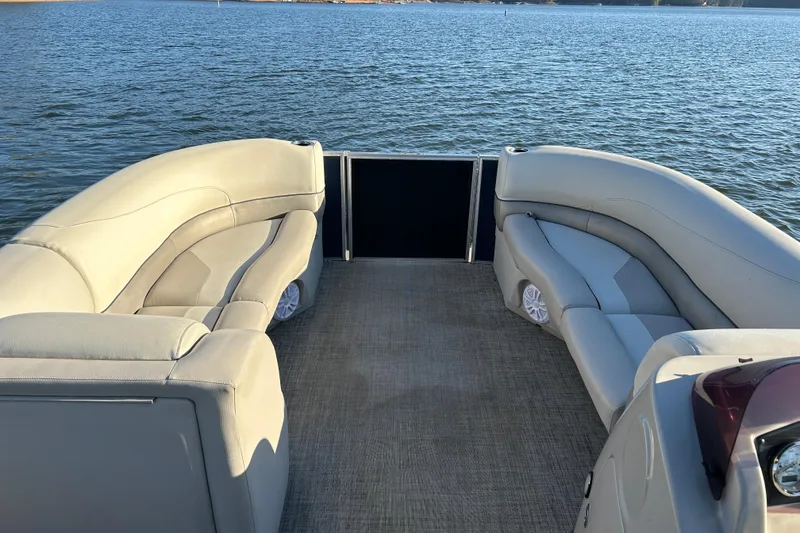 Slide: The Image of 2022 Cypress Cay Seabreeze 232 pontoon boat interior with plush seating on a calm lake. - 9
