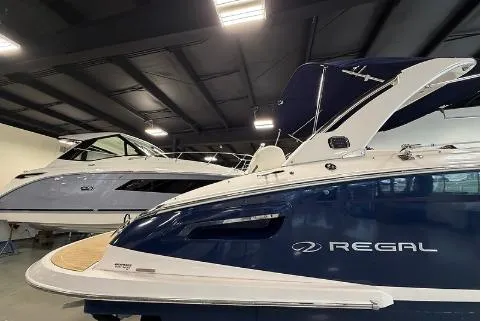 Slide: The Image of 2020 Regal 2800 Bowrider boat in showroom, sleek design, blue and white exterior. - 3