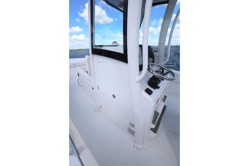 Slide: The Image of 2026 Sea Hunt Ultra 275 Coffin Box boat helm with steering wheel and controls. - 16