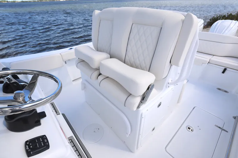 Slide: The Image of 2026 Sea Hunt Ultra 275 Coffin Box boat interior with plush seating and steering wheel. - 19