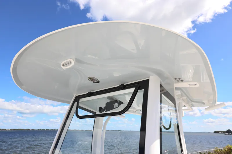 Slide: The Image of 2026 Sea Hunt Ultra 275 Coffin Box boat with rod holders and speakers, under blue sky. - 22