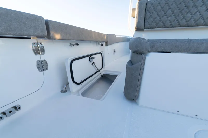 Slide: The Image of 2026 Sea Hunt Ultra 275 Coffin Box boat interior with open storage compartments on a serene lake. - 42