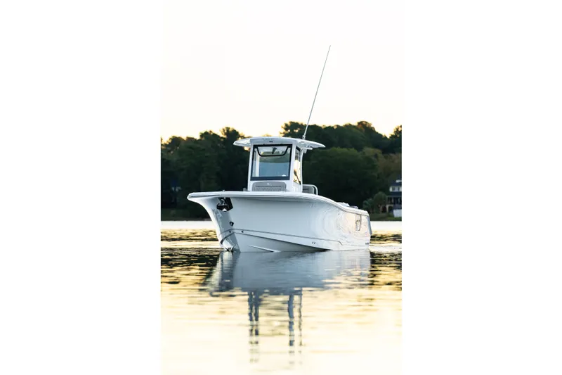 Slide: The Image of 2026 Sea Hunt Ultra 275 Coffin Box boat on calm water, surrounded by trees. - 47