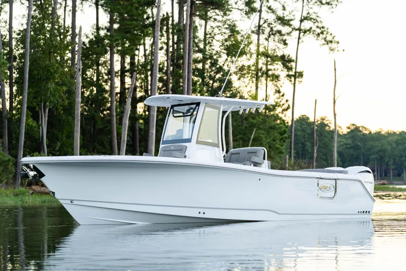 Slide: The Image of 2026 Sea Hunt Ultra 275 Coffin Box boat with dual engines, docked on calm water. - 48