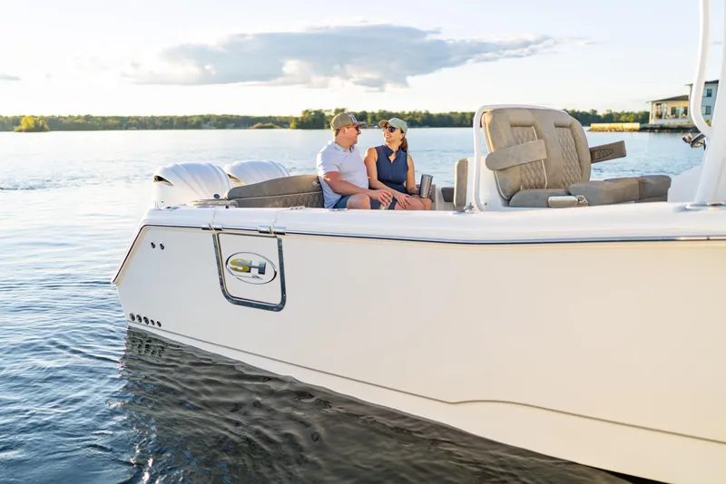 Slide: The Image of 2026 Sea Hunt Ultra 275 Coffin Box cruising on a serene lake with passengers. - 57