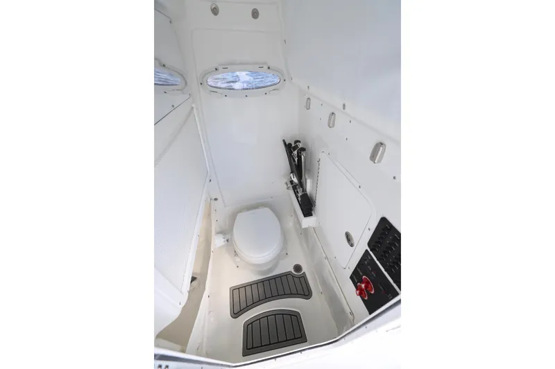 Slide: The Image of Interior of 2026 Sea Hunt Ultra 275 Coffin Box boat, featuring a compact marine toilet. - 7