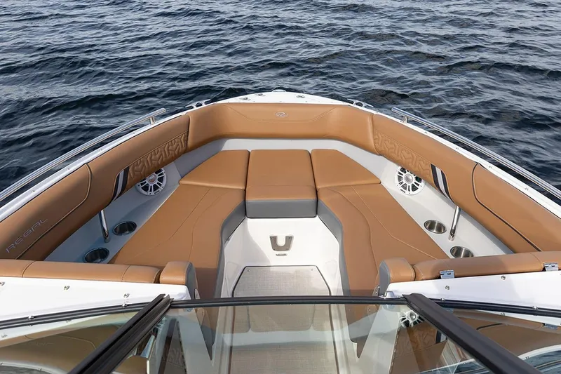 Slide: The Image of Manufacturer Provided Image: Luxurious 2026 Regal LX4 boat interior with tan seating, cup holders, and speakers on open water. - 4