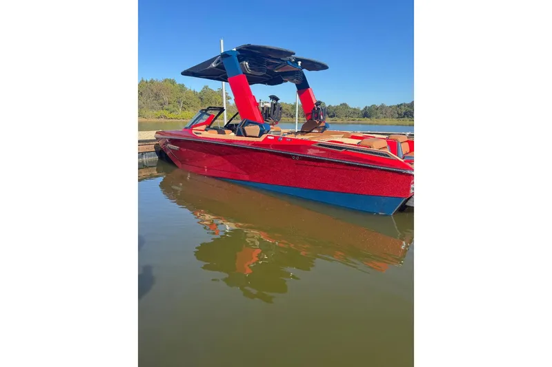 Slide: The Image of 2021 Nautique Super Air Nautique G23 Paragon in vibrant red, docked on a sunny day. - 12