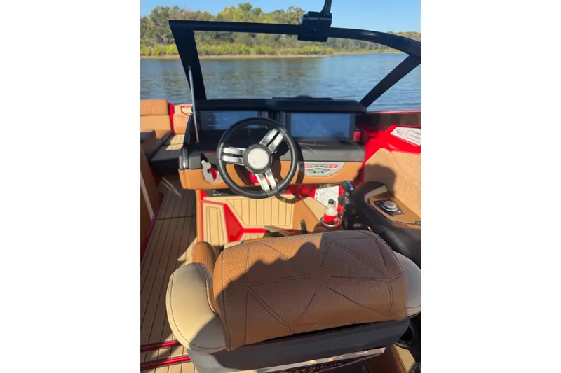 Slide: The Image of Interior of 2021 Nautique Super Air Nautique G23 Paragon boat, featuring steering wheel and dashboard. - 5