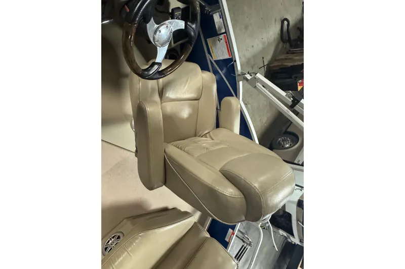 Slide: The Image of Captain's chair on 2014 SunCatcher Elite 322 Cruise boat, featuring beige leather upholstery. - 17
