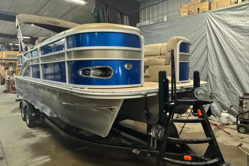 Slide: The Image of 2014 SunCatcher Elite 322 Cruise pontoon boat in a garage setting. - 2