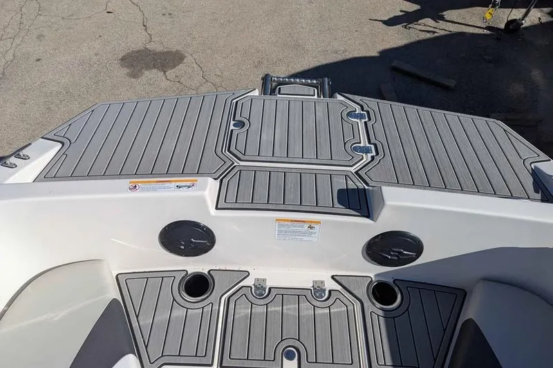 Slide: The Image of 2026 Starcraft SVX 171 OB boat deck with gray non-slip surface and cup holders. - 13
