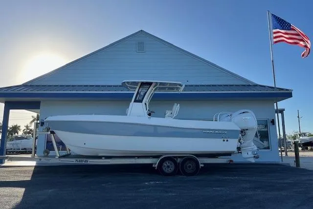 The Image of 2026 World Cat 235 TE boat on trailer, parked by building with American flag. - 1