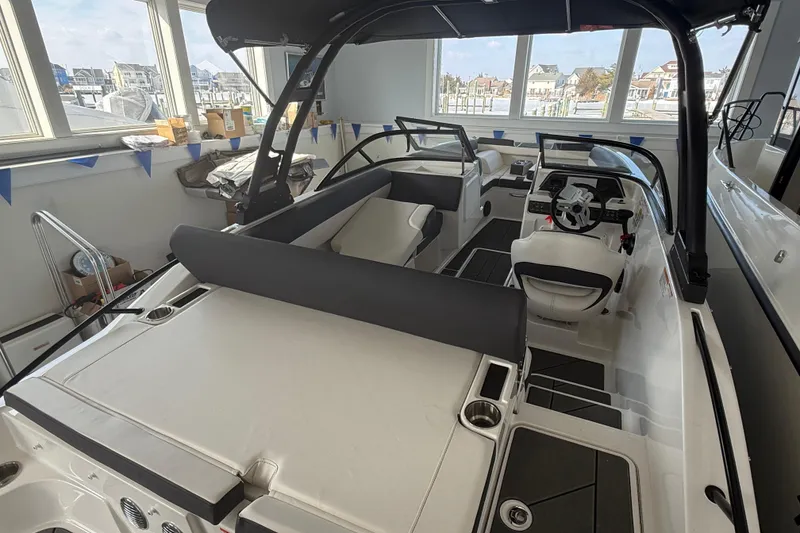 Slide: The Image of 2026 Bayliner D20 boat interior with sleek seating and modern dashboard in showroom. - 11
