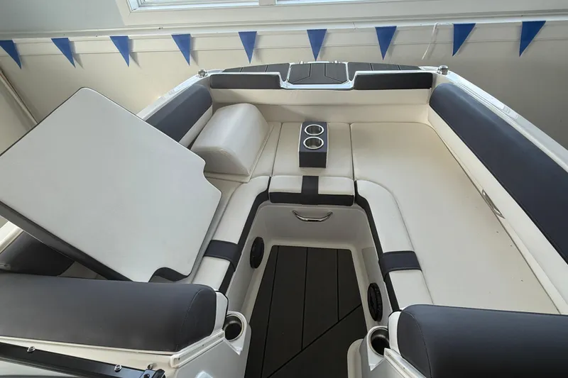 Slide: The Image of Interior of 2026 Bayliner D20 boat with cushioned seating and cup holders. - 14