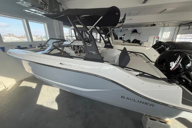The Image of 2026 Bayliner D20 boat in showroom, featuring sleek design and Mercury outboard engine. - 9