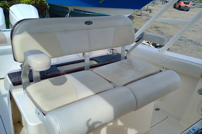 Slide: The Image of 2010 Pursuit S 280 Sport boat seating with white cushions and armrests. - 10