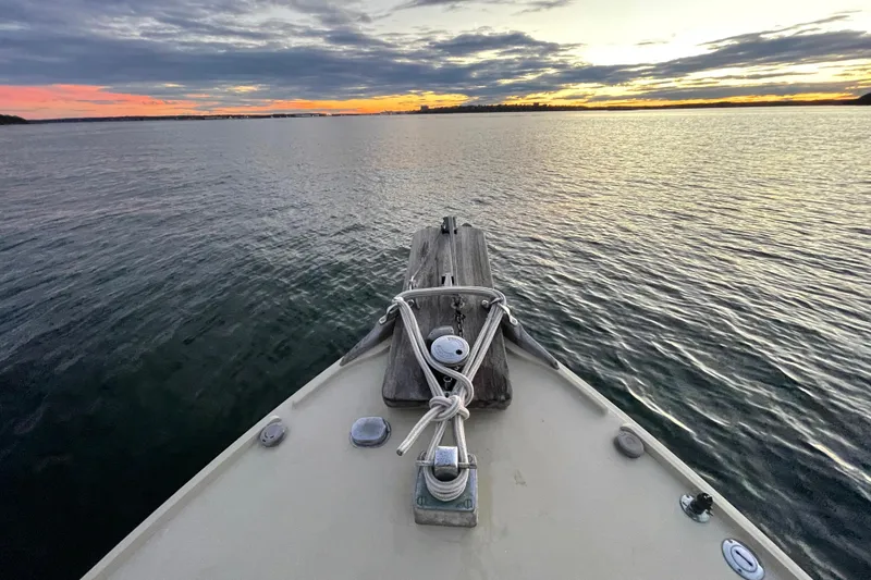 Slide: The Image of 1981 Holland 32 Sport Cruiser on calm waters, showcasing its deck and cabin. - 9