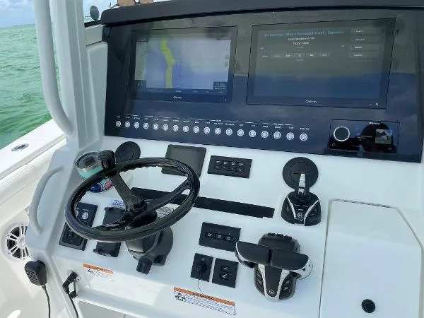 Slide: The Image of Control panel of a 2021 Regulator 34 boat with navigation screens and steering wheel. - 16