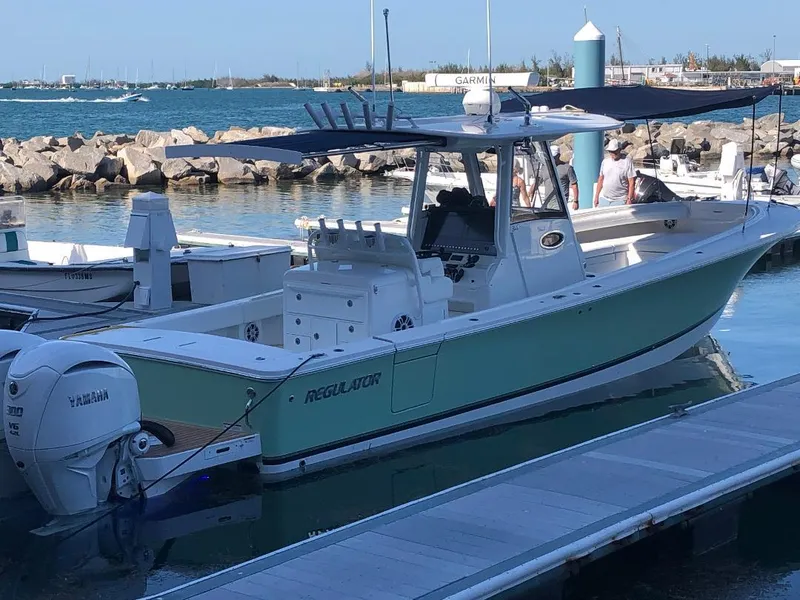 Slide: The Image of 2021 Regulator 34 boat docked, featuring Yamaha engines, in a scenic marina setting. - 3