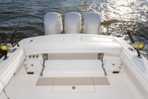 Slide: The Image of 2021 Regulator 34 boat with triple engines, fishing rods, and seating on open water. - 8