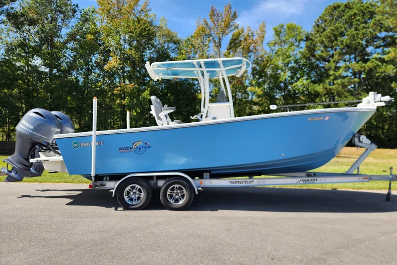 The Image of 2025 May-Craft 245 Offshore CC boat on trailer, blue hull, parked outdoors. - 0