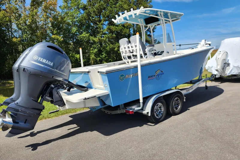 Slide: The Image of 2025 May-Craft 245 Offshore CC boat with Yamaha engine on trailer, outdoors. - 2